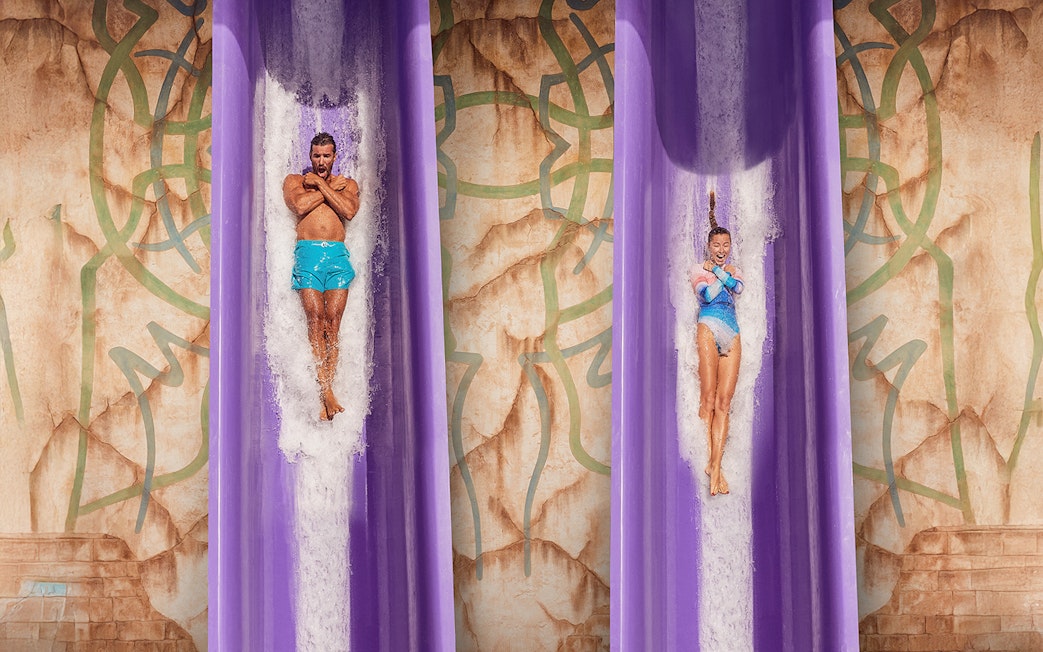 Two people sliding down the Blackout adventure ride at Atlantis, The Palm, Dubai.