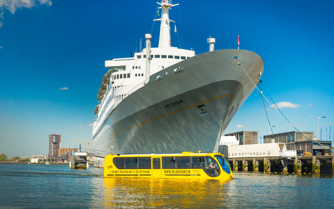 Rotterdam Splash Tour amphibious bus entering water with city skyline in background.