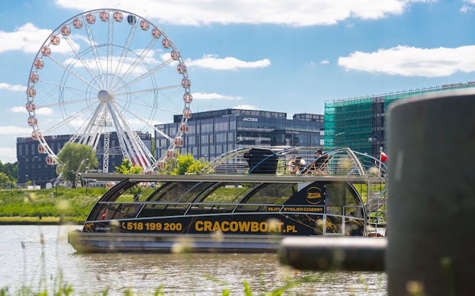 Krakow Vistula River cruise boat with Ferris wheel in the background.