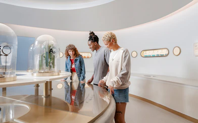 Friends exploring interactive exhibit at World of Coca-Cola Museum, Atlanta.