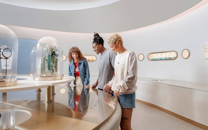 Friends exploring interactive exhibit at World of Coca-Cola Museum, Atlanta.