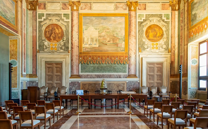 Interior of St. John Lateran with ornate frescoes and seating area for audio guide tour.