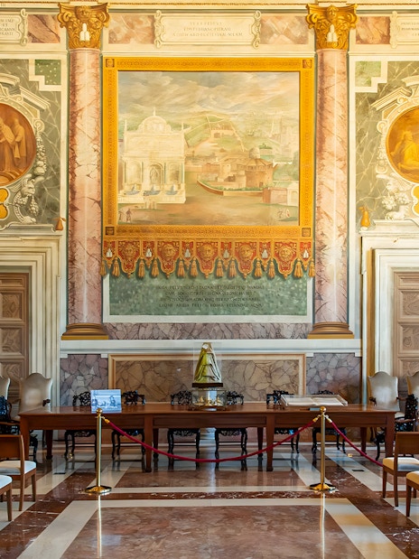 Interior of St. John Lateran with ornate frescoes and seating area for audio guide tour.