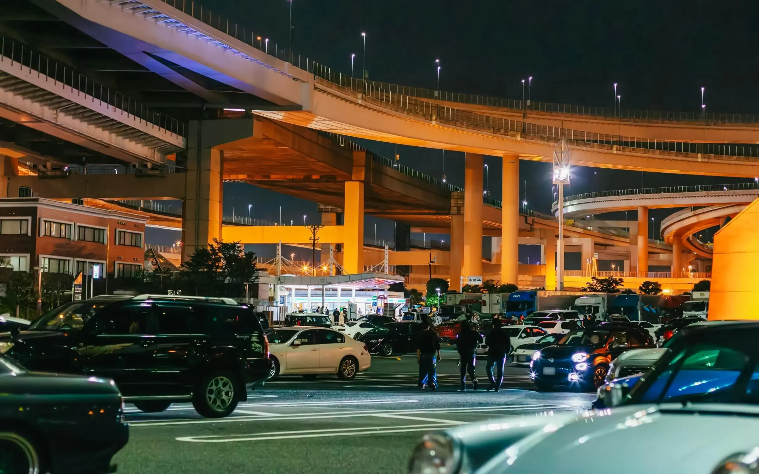 Tokyo highway at night with cars and people, setting for Fast & Furious Tokyo Drift III Experience.