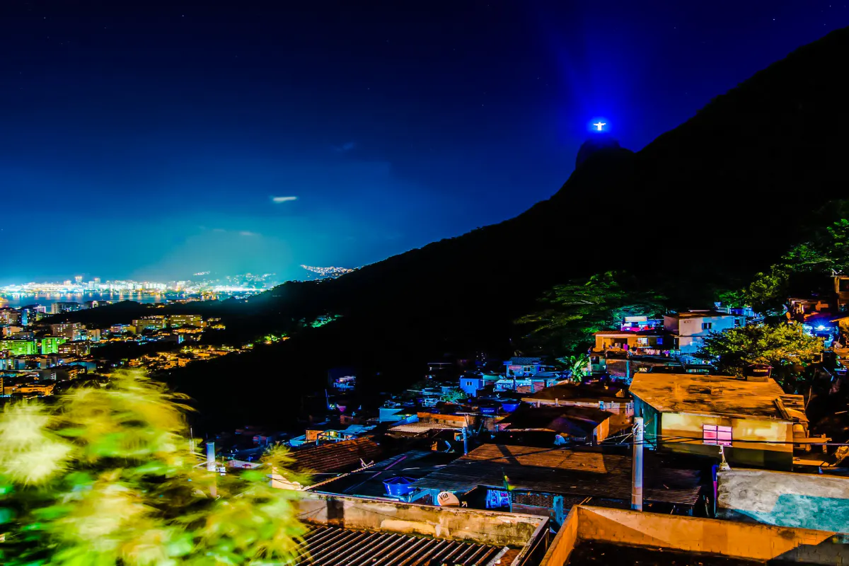 Rocinha Favela at night with Christ the Redeemer statue illuminated in Rio de Janeiro.