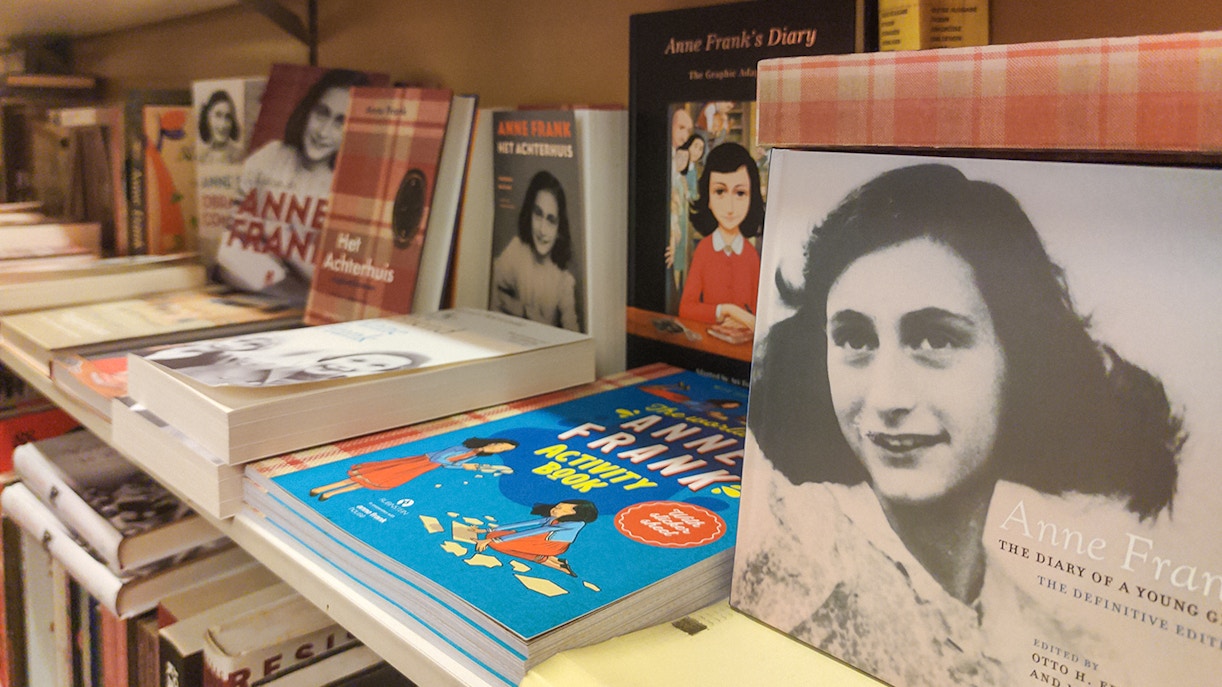 Anne Frank books displayed on a shelf, part of The Life of Anne Frank Bike Tour.