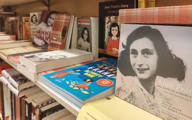 Anne Frank books displayed on a shelf, part of The Life of Anne Frank Bike Tour.