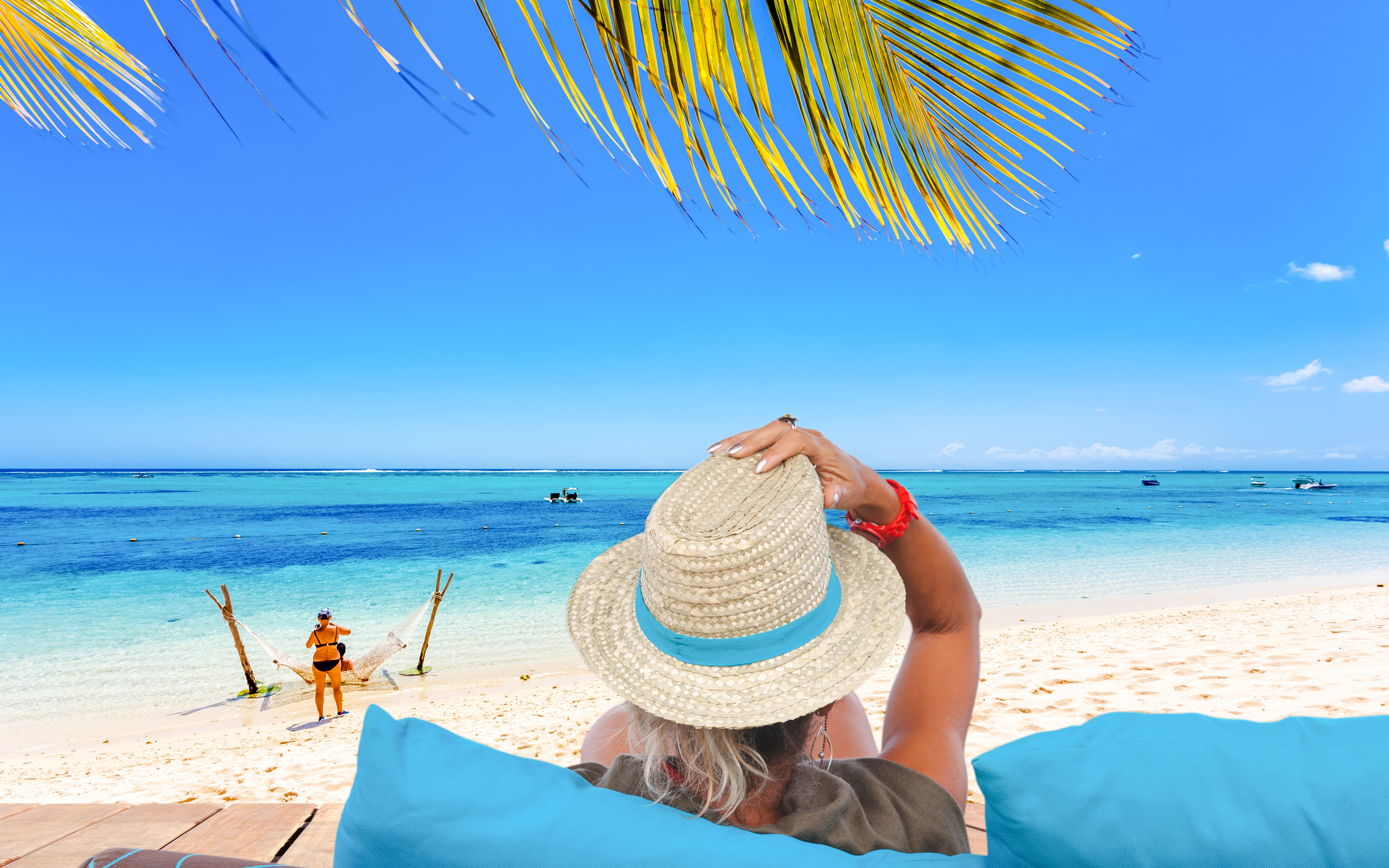 Relaxing on a beach in Mauritius with a view of the ocean and palm leaves.