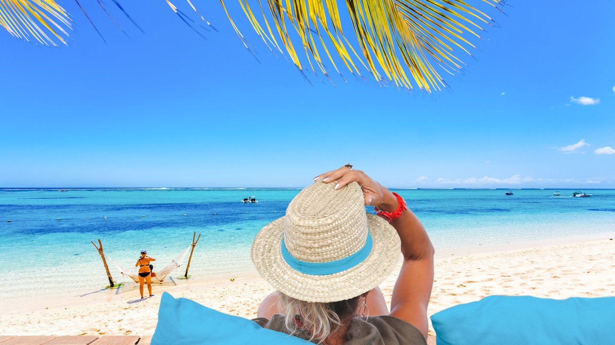 Relaxing on a beach in Mauritius with a view of the ocean and palm leaves.