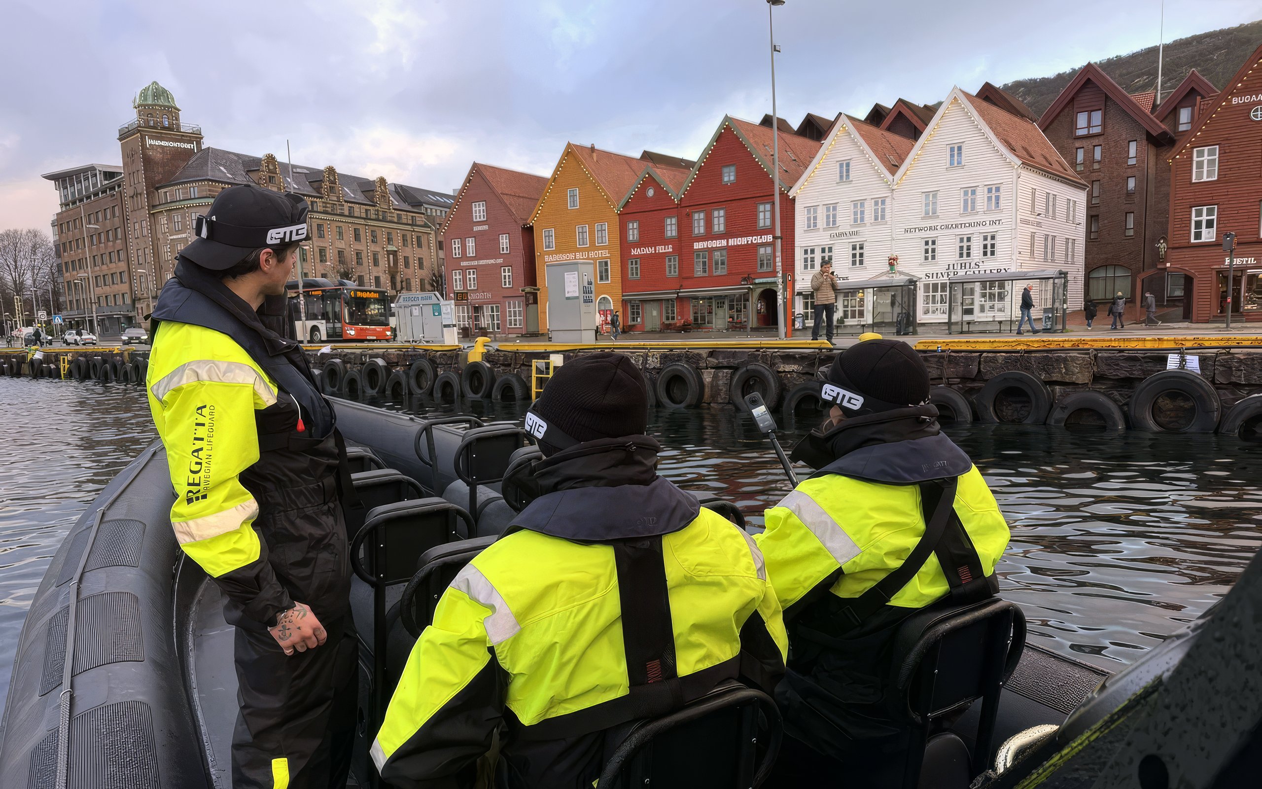 Tour group arriving by boat at a colorful waterfront city with historic wooden houses.