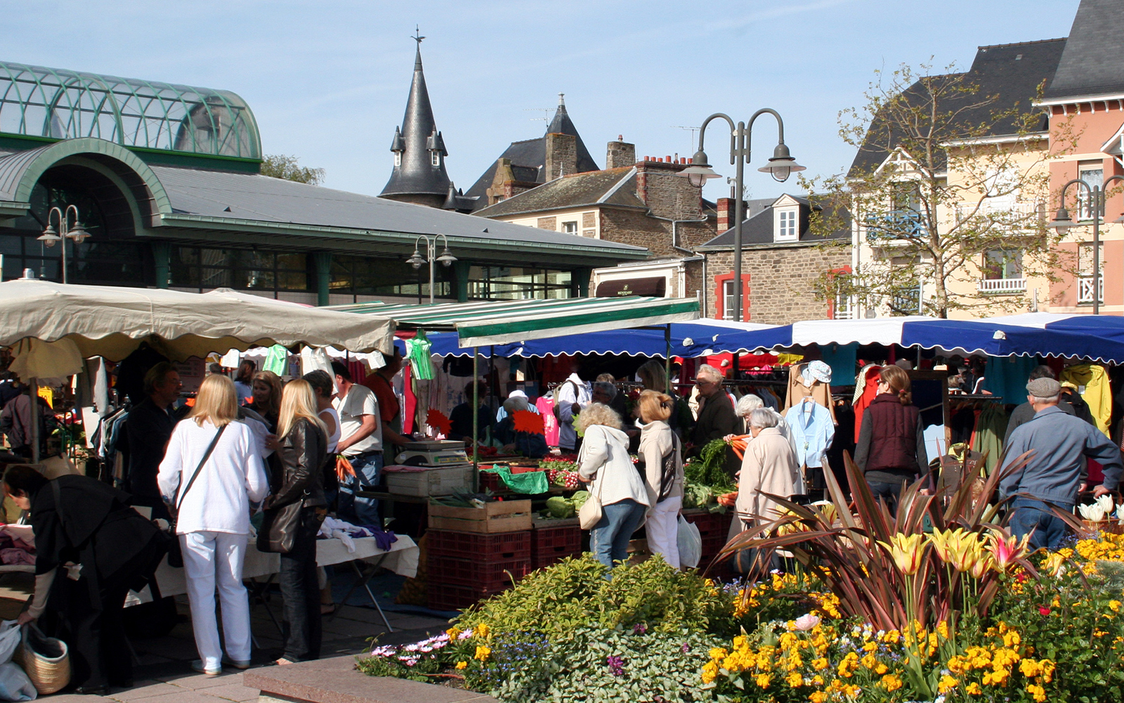 Shoppers explore stalls at Marché de Saint-Denis, with fresh produce and flowers in Saint Denis Market.