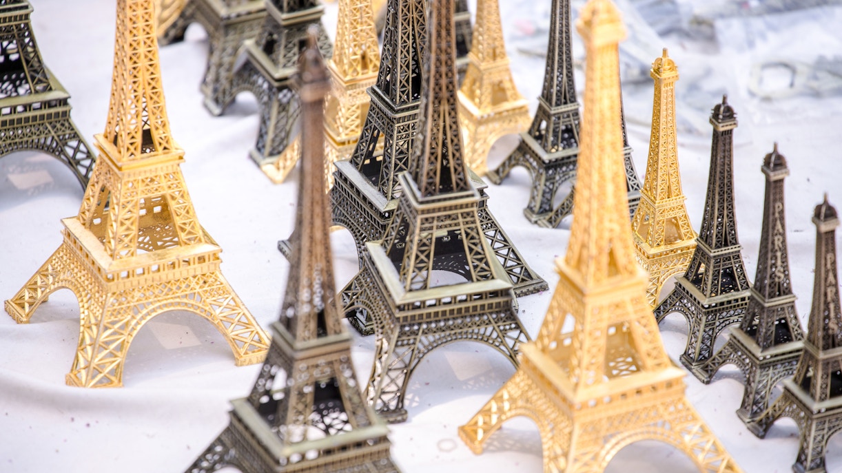 Miniature Eiffel Tower souvenirs displayed on a table in Paris.