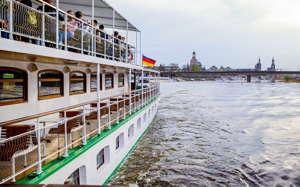 Sightseeing cruise on the Elbe River with Dresden skyline in the background.