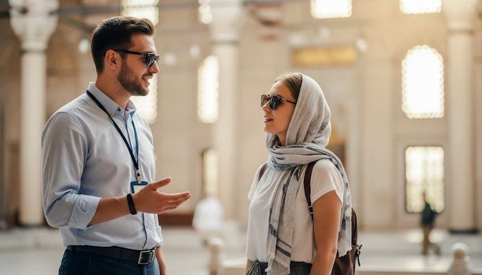 Tour guide speaking with woman tourist inside Suleymaniye Mosque, Istanbul.