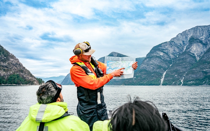 Guide explaining sea map to guests during Whale Watching tour in Husavik.