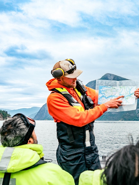 Guide explaining sea map to guests during Whale Watching tour in Husavik.