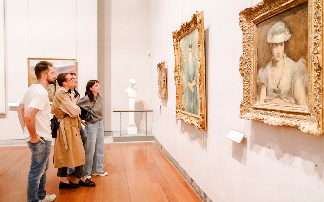 Visitors observing paintings at the Museum of Fine Arts, Lyon, France.