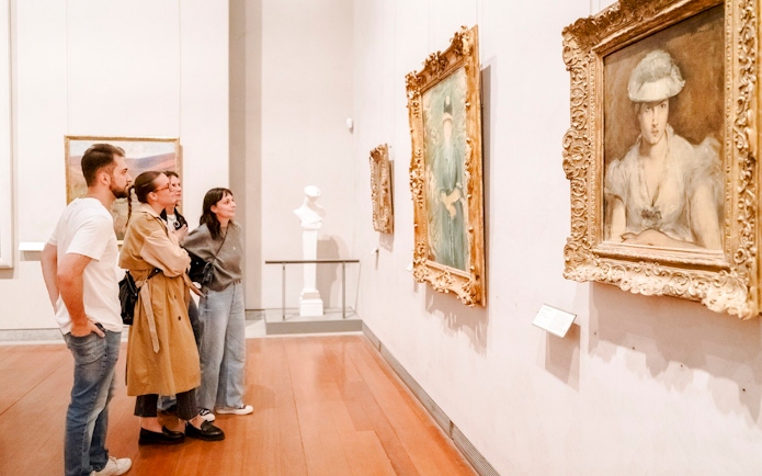 Visitors observing paintings at the Museum of Fine Arts, Lyon, France.