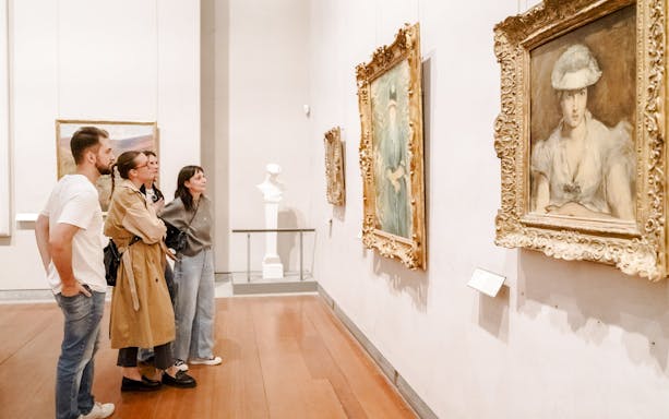 Visitors observing paintings at the Museum of Fine Arts, Lyon, France.