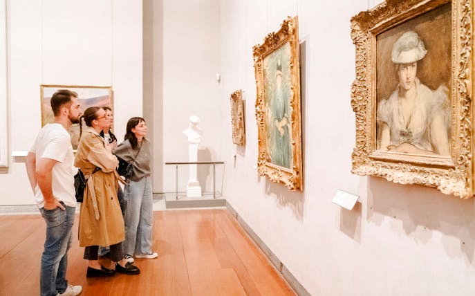 Visitors observing paintings at the Museum of Fine Arts, Lyon, France.