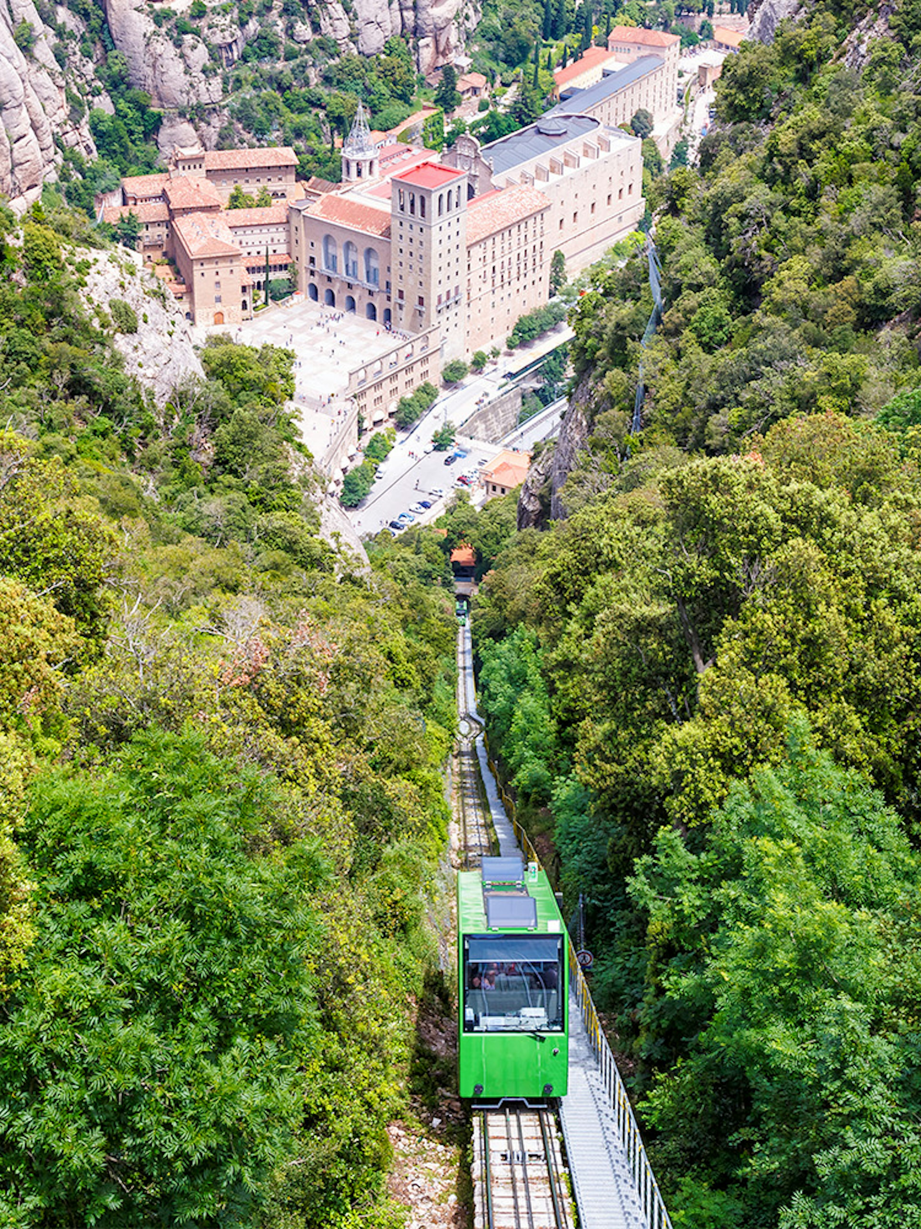 Cog-wheel train ascending to Montserrat Monastery with lush mountain views.