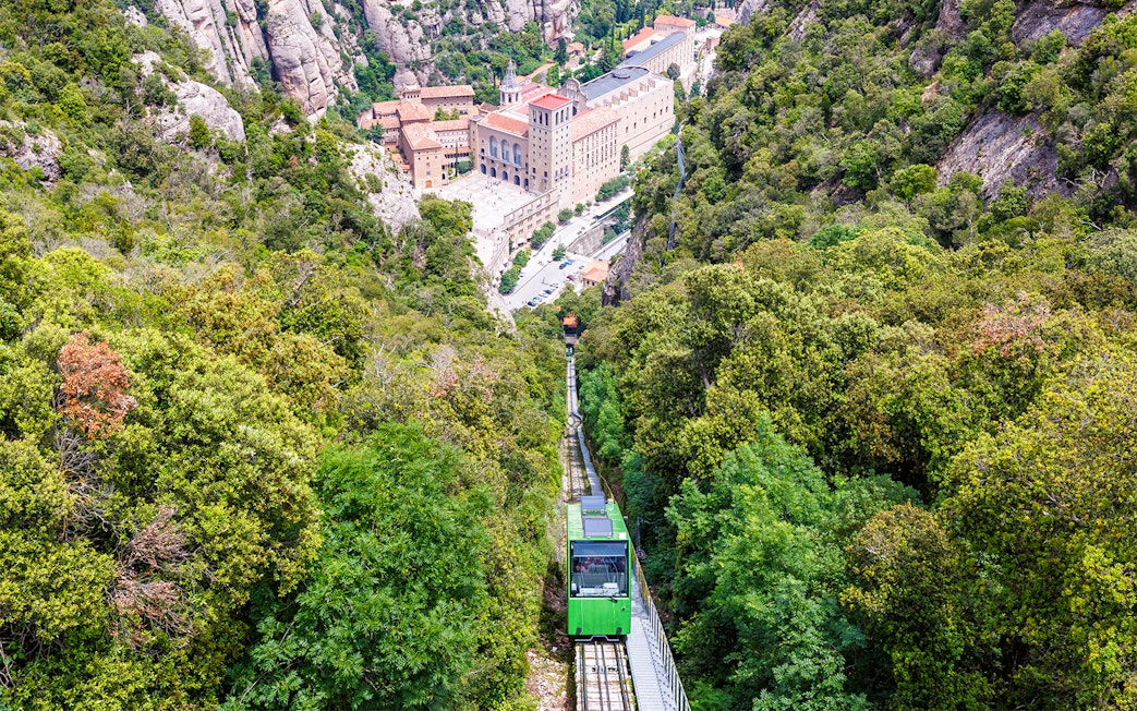 Cog-wheel train ascending to Montserrat Monastery with lush mountain views.