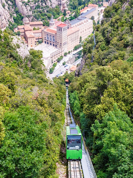 Cog-wheel train ascending to Montserrat Monastery with lush mountain views.