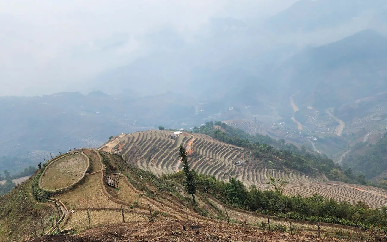 Rice terraces and hills in Mu Cang Chai, Vietnam, viewed from a trekking path.