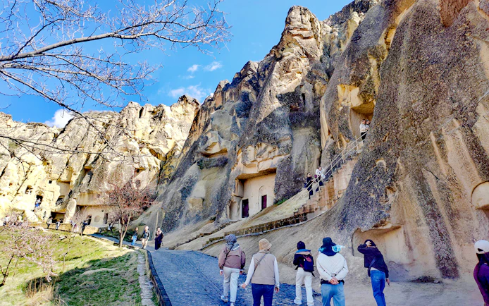 Visitors exploring rock-cut churches at Göreme Open Air Museum, Cappadocia.