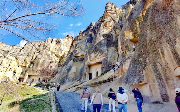 Visitors exploring rock-cut churches at Göreme Open Air Museum, Cappadocia.