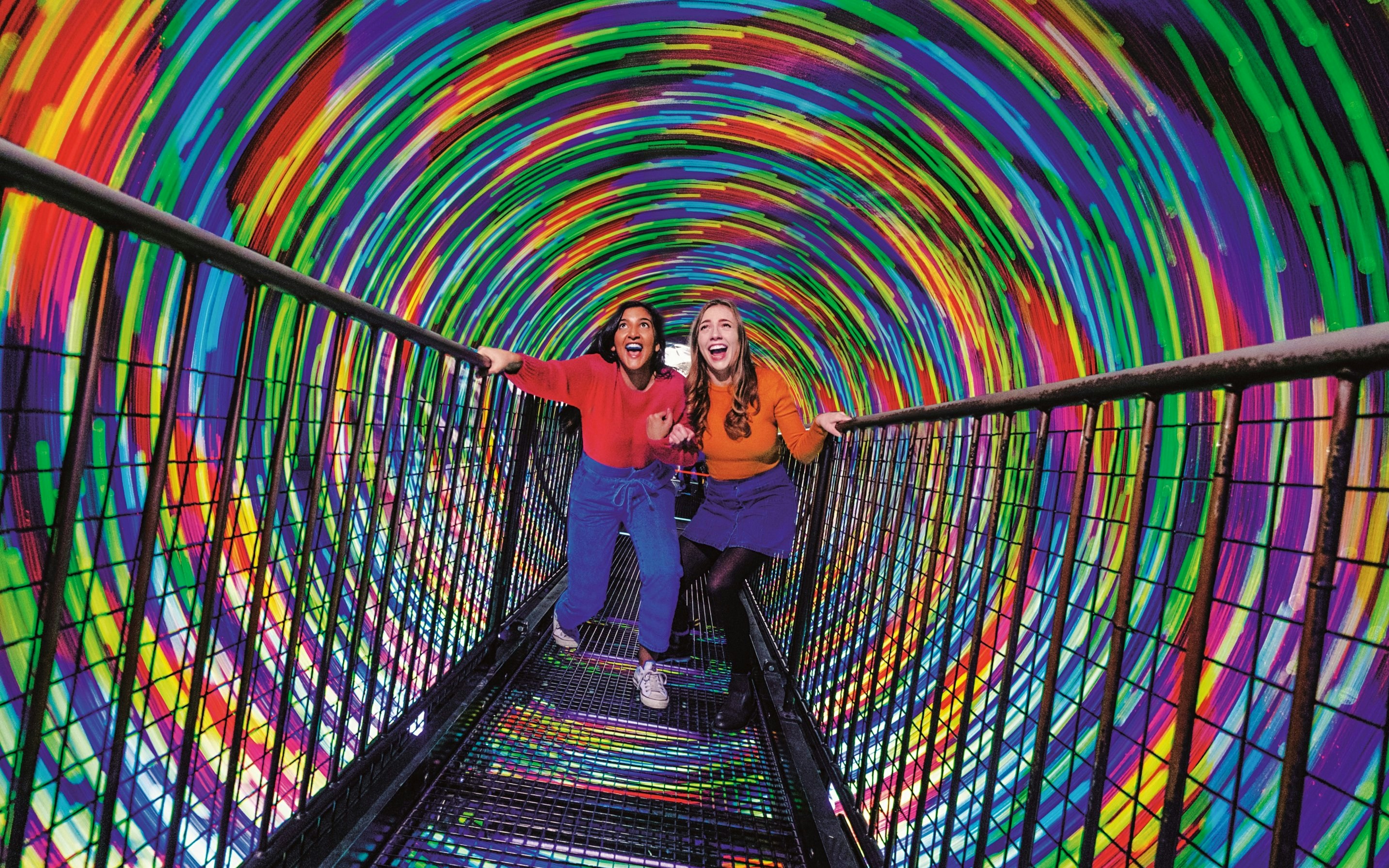 Visitors walking through the colorful Vortex Tunnel at Camera Obscura & World of Illusions, Edinburgh.
