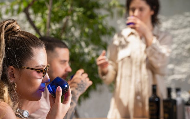 Tasting olive oil in Santorini with blue glasses.