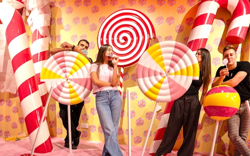 Guests posing with giant candy props at Museum of Candy.