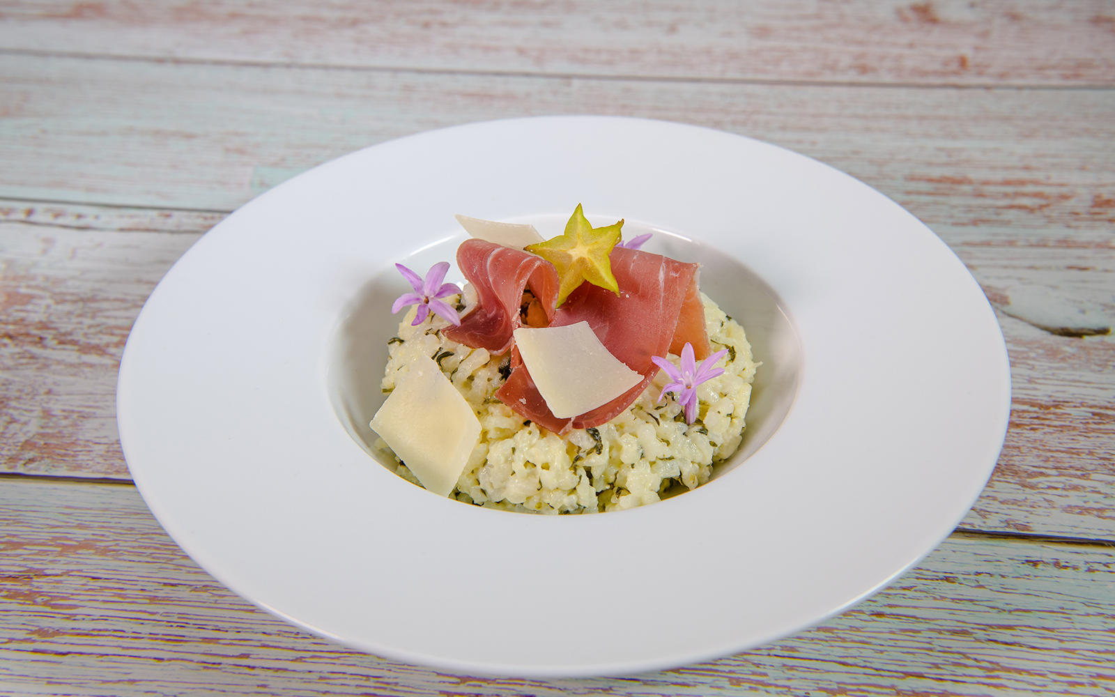 Goat cheese risotto with prosciutto and starfruit garnish in Douro Valley.