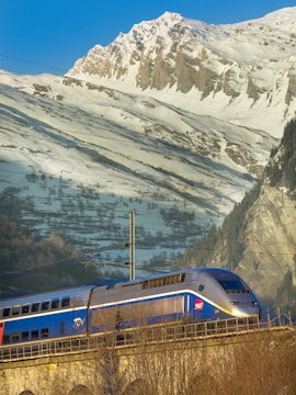 High-speed train traveling through snowy Alps, promoting Interrail Passes.