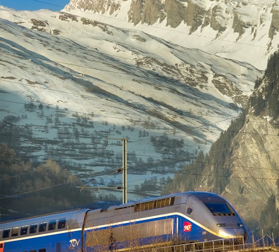 High-speed train traveling through snowy Alps, promoting Interrail Passes.