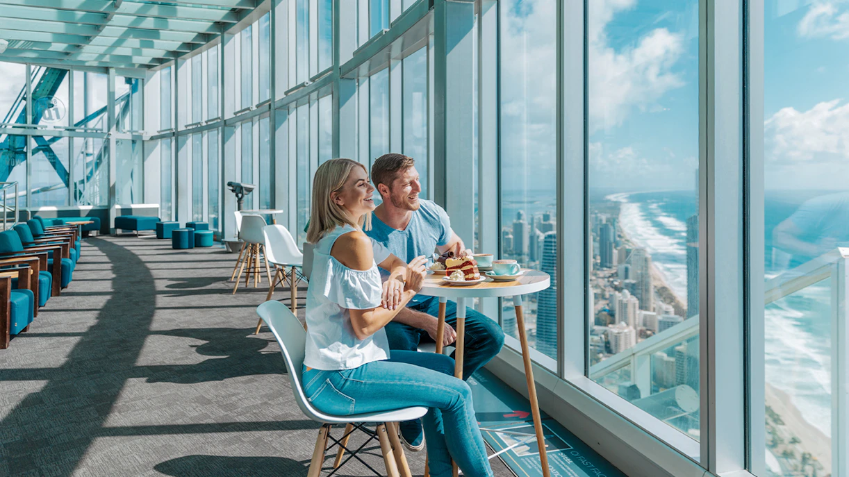 Couple dining with city and ocean views at SkyPoint Observation Deck, Gold Coast.