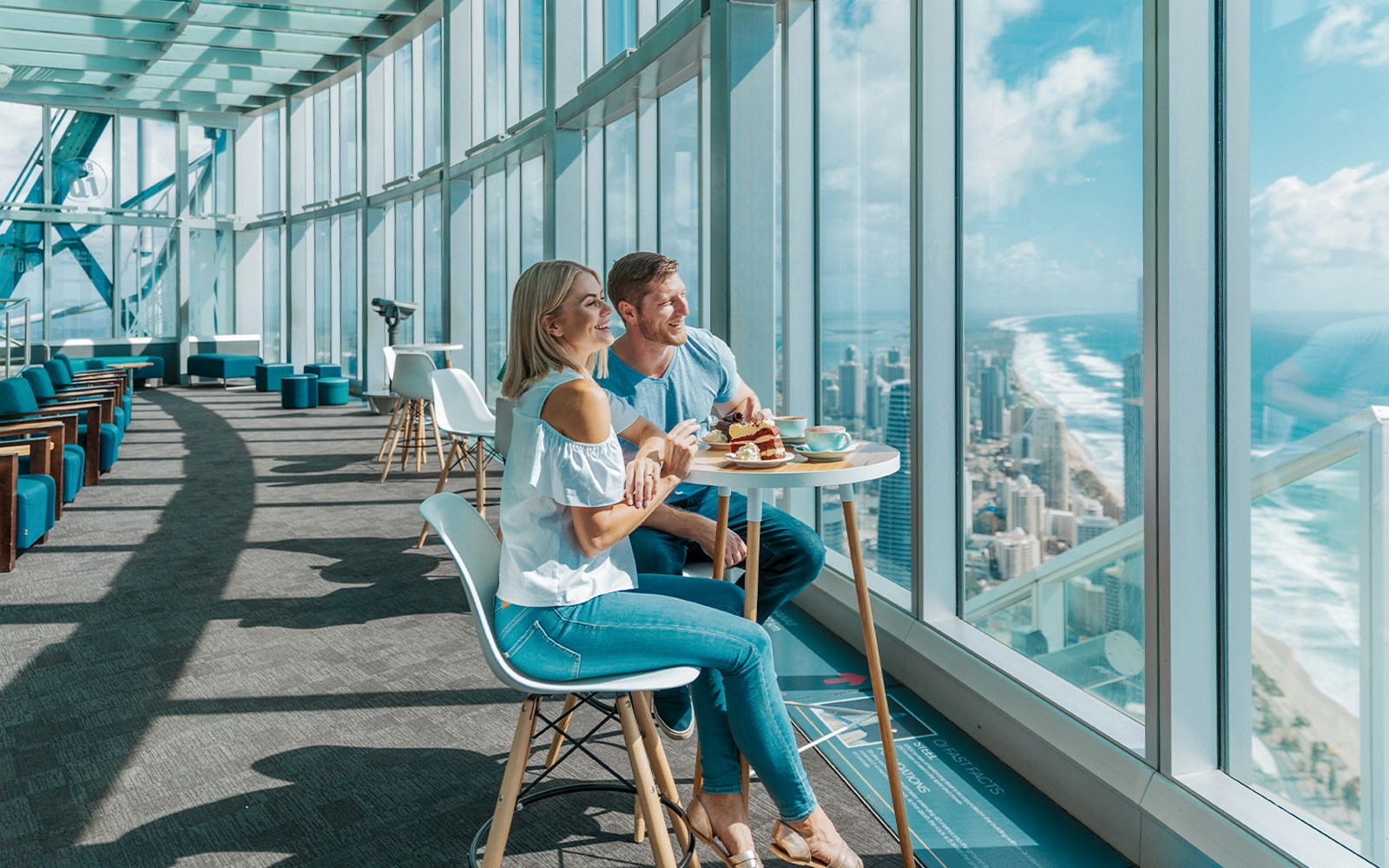 Couple dining with city and ocean views at SkyPoint Observation Deck, Gold Coast.