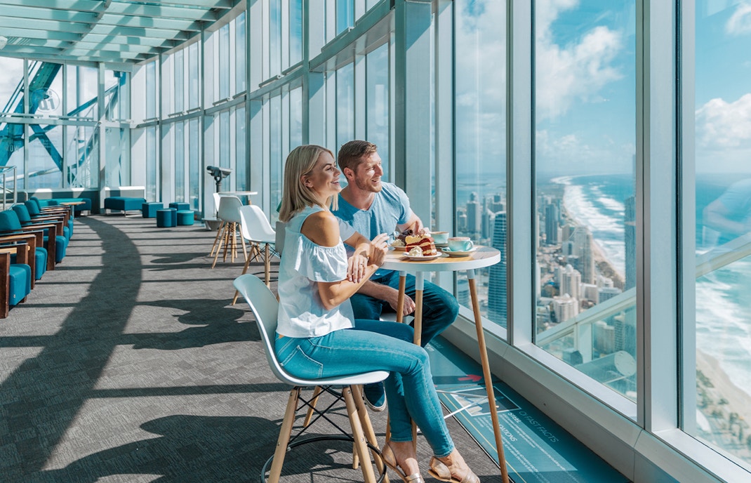 Couple dining with city and ocean views at SkyPoint Observation Deck, Gold Coast.