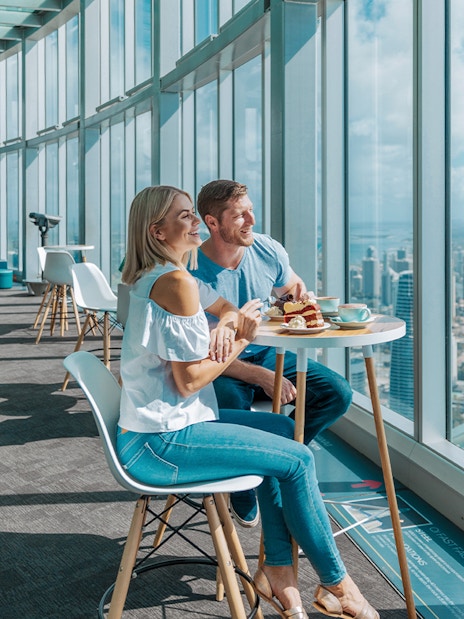 Couple dining with city and ocean views at SkyPoint Observation Deck, Gold Coast.