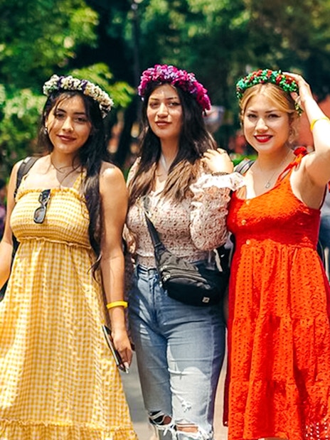 Women wearing floral crowns posing in Coyoacán, Mexico City.