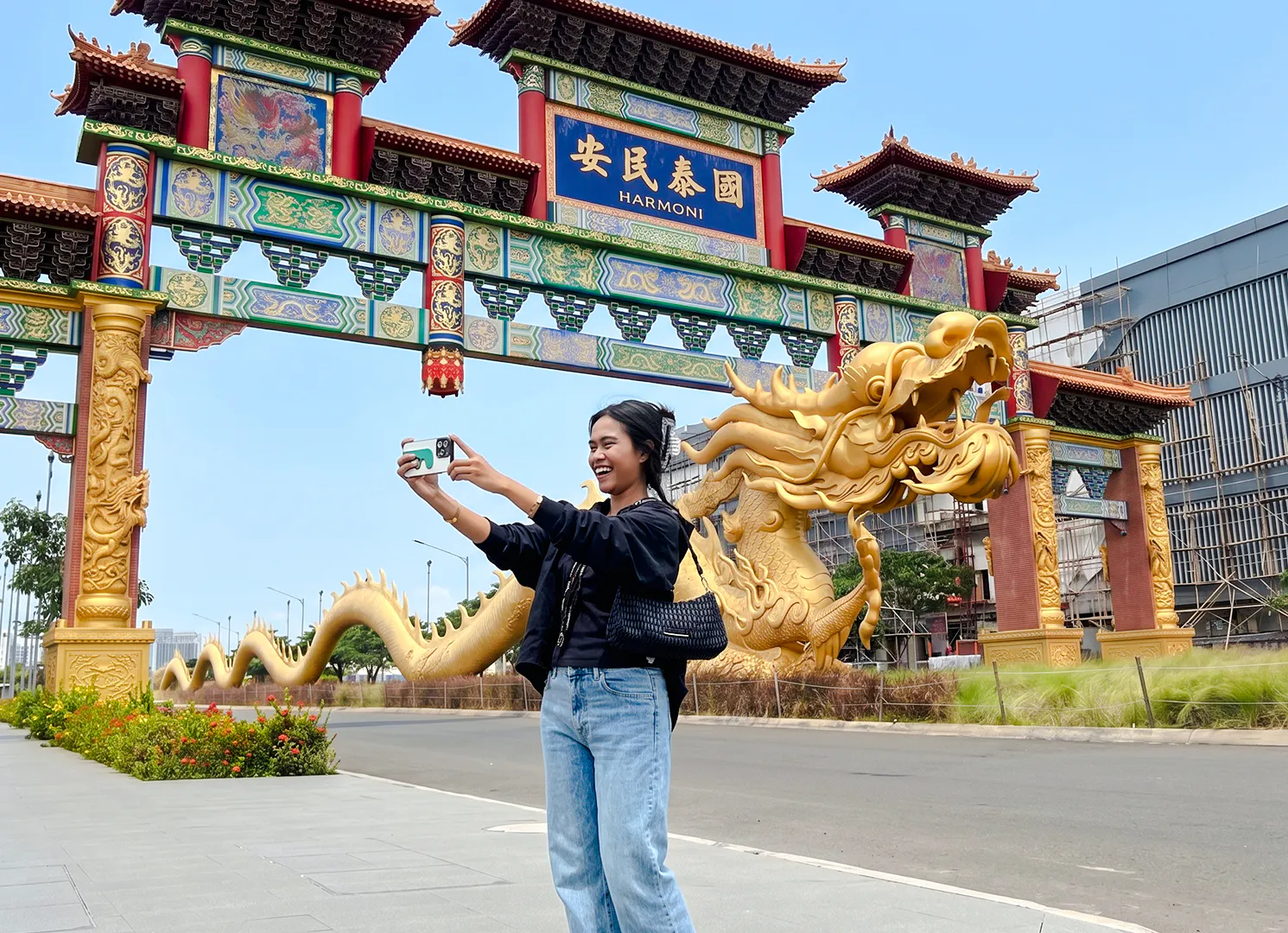 Person taking a selfie at the ornate entrance gate in Jakarta's Chinatown Glodok.