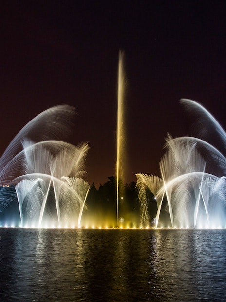 Fountain show at night, Palace of Versailles, with illuminated water jets.