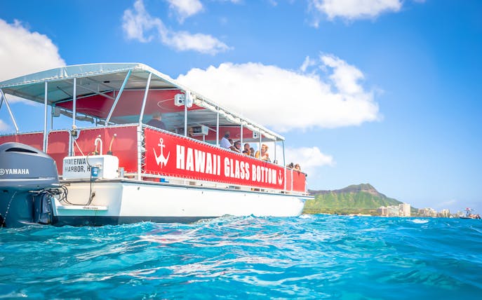 Hawaii glass-bottom boat tour off Waikiki coast with Diamond Head in background.