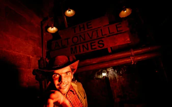 Guide in costume at Altonville Mines during Alton Towers Scarefest.