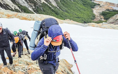 Trekking group climbing snowy terrain on Ojo del Albino Glacier, Argentina.