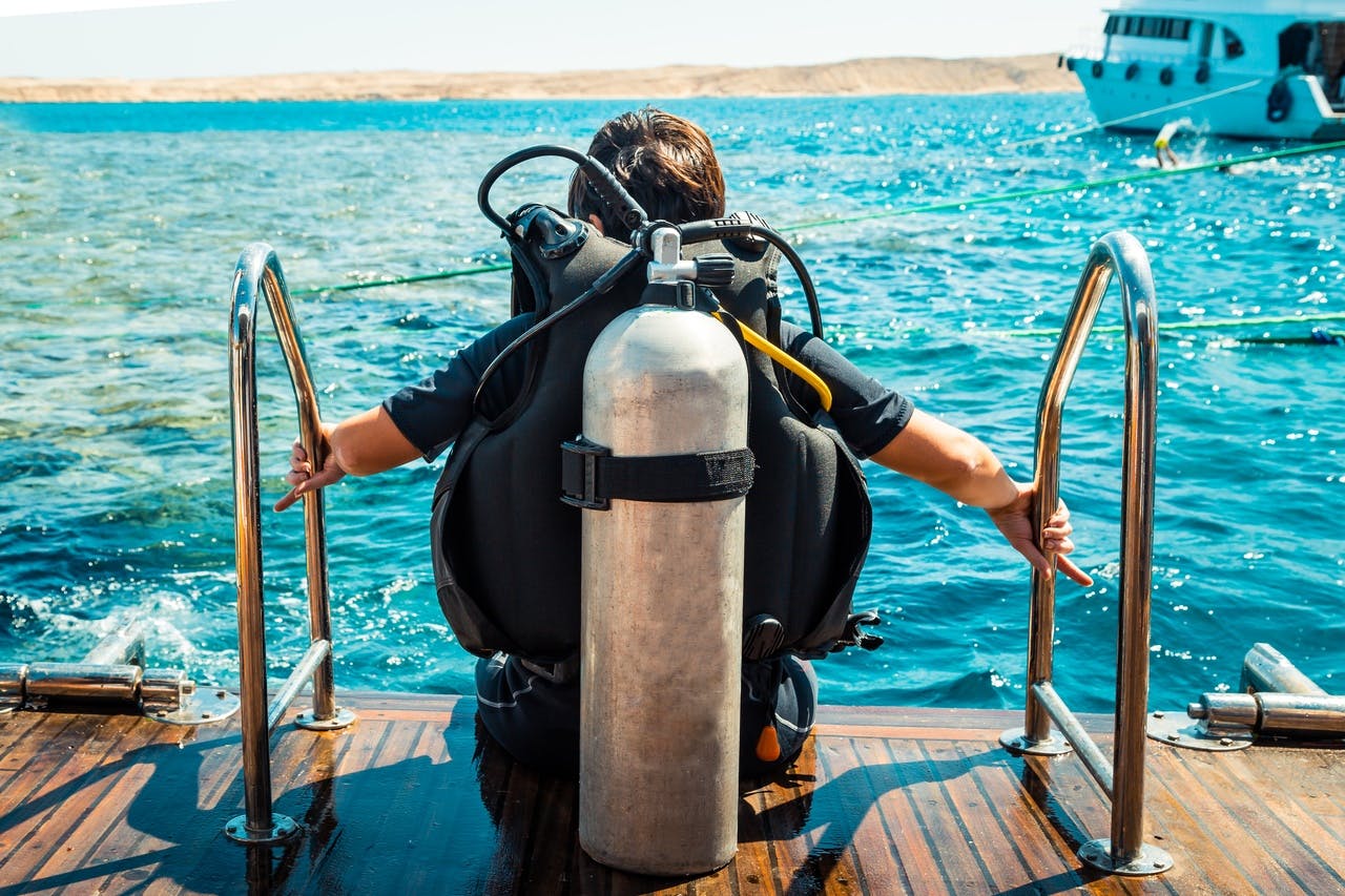 Scuba diver preparing to enter Red Sea from boat, Hurghada.