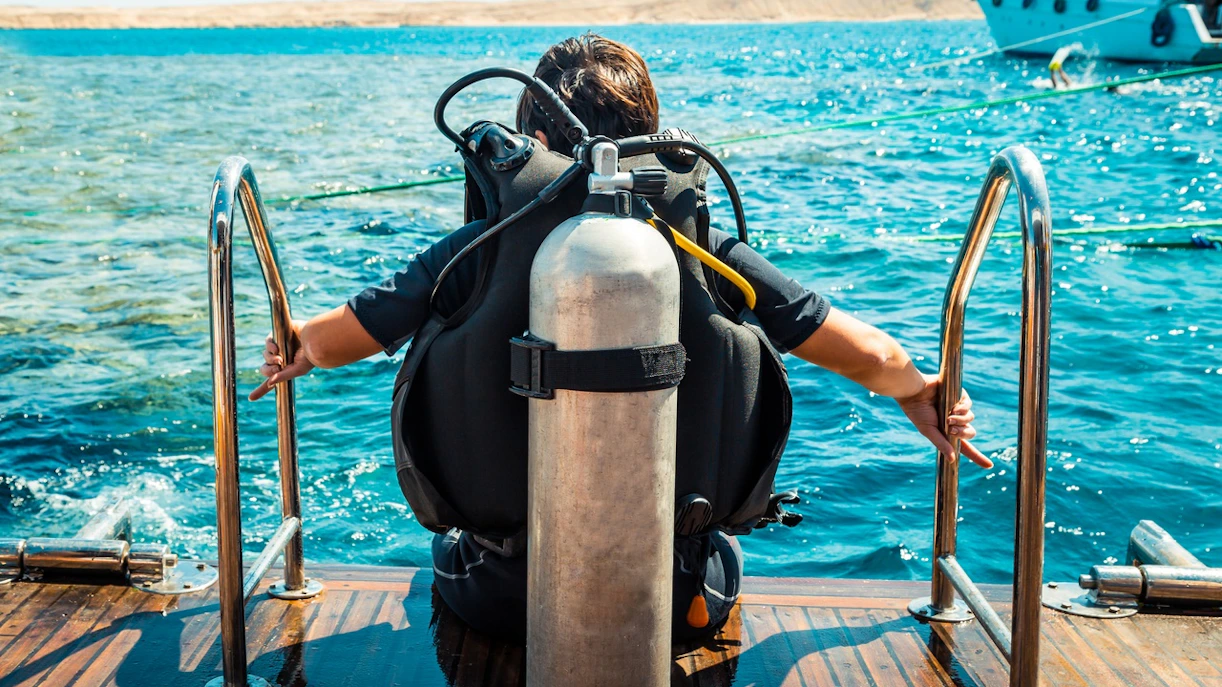 Scuba diver preparing to enter Red Sea from boat, Hurghada.