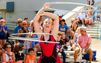Performer with hula hoops entertaining crowd at State Fair of Texas.