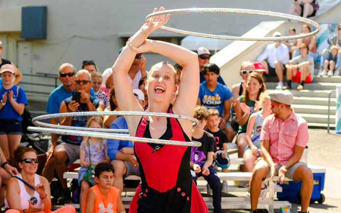 Performer with hula hoops entertaining crowd at State Fair of Texas.